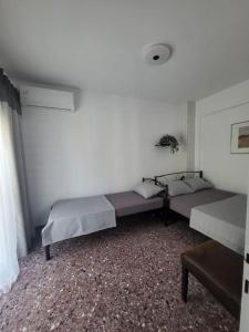 a room with two beds and a table in it at "BenLin" 3 in Paralia Katerinis