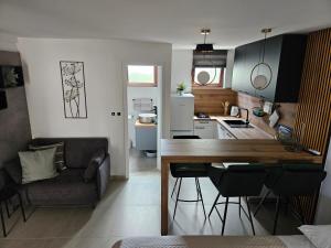 Apartments Frama Poreč - Funtana في فونتانا: مطبخ وغرفة معيشة مع طاولة وكراسي