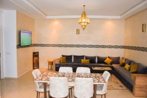 un salon avec un canapé, une table et des chaises dans l'établissement Appartement tout confort, à Essaouira