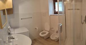 a white bathroom with a toilet and a sink at APPARTAMENTI VACANZA SAN SILVESTRO in Piobbico +12 photos