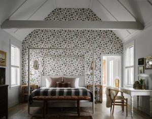 a bedroom with a bed with a patterned wall at Hidden Pond Resort in Kennebunkport