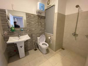 een badkamer met een toilet en een wastafel bij Luxe Suites Bahria Town Lahore in Lahore