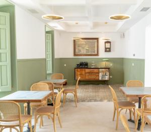 una habitación con mesas, sillas y un piano en Casa del Médico Hotel Boutique, en Alcázar de San Juan