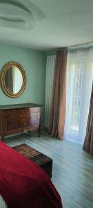 - une chambre avec un lit, un miroir et une fenêtre dans l'établissement La Casa della Rosa Nana, à Trezzano sul Naviglio