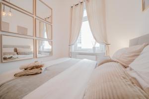 ein weißes Schlafzimmer mit einem großen Fenster und einem Bett in der Unterkunft LLR Design Apartment - Sienna Beige im Zentrum von Koblenz in Koblenz