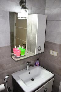 a bathroom with a sink and a mirror and some cups at Appartement tout confort in Essaouira