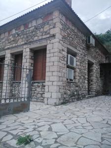 kamienny dom z drzwiami i kamiennym patio w obiekcie Αρχωντικα στην Τρiχονιδα w mieście Agrinio