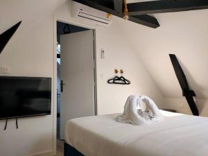 Schlafzimmer mit einem Bett und einem Flachbild-TV in der Unterkunft Dakar - Bel appartement à Reims in Reims