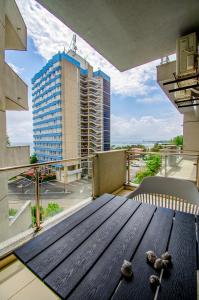 a table on a balcony with a view of a building at Sara Sea View Apartments - ByChoice in Olimp