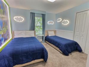 2 letti in una camera da letto con pareti blu e nuvole sul muro di ST3064 Fabulosa casa perto da Disney a Kissimmee