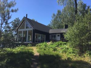 une petite maison noire avec des fenêtres et des arbres dans l'établissement Egen Ö med unik upplevelse, 