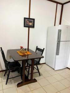 a kitchen with a table and a refrigerator at Maya Mountain Lodge in San Ignacio