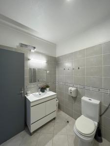a bathroom with a toilet and a sink at Villa Paradis Pêra - Quartos para férias in Pêra