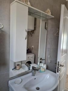 a bathroom with a sink and a mirror at Dream Vacation Apartment in Acharavi