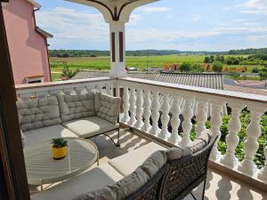 d'un balcon avec des chaises et une table sur une terrasse couverte. dans l'établissement Apartments Frama Poreč - Funtana, à Funtana