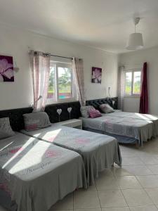 a bedroom with two beds and a couch at Villa Paradis Pêra - Quartos para férias in Pêra