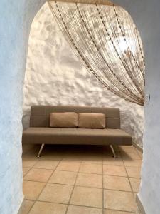 ein Sofa in einem Zimmer mit einem großen Kronleuchter in der Unterkunft Casa Cueva LA PARRA. in Terque