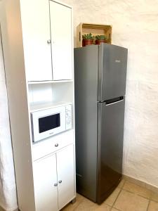 eine Küche mit einem Kühlschrank und einer Mikrowelle in der Unterkunft Casa Cueva LA PARRA. in Terque