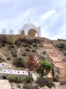 a church sitting on top of a hill with a cross at Casa Cueva LA PARRA. in Terque