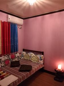 a bedroom with a bed with colorful curtains at Leigh HomeStay in Alaminos