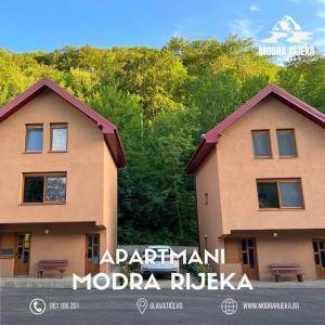 un paio di edifici di fronte ad alcuni alberi di Modra Rijeka Resort a Glavatičevo