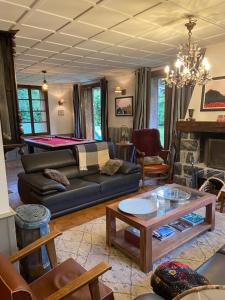 a living room with a couch and a pool table at Le Petit Poucet Appartement rez-de-chaussée avec grand jardin in Morzine
