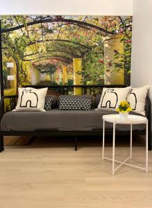 un divano nero in una stanza con un dipinto di casa Tolinda 2 a Bolsena