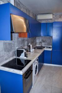 una cucina blu con lavandino e forno a microonde di Appartamento Urbino a Urbino