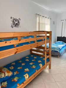 a bedroom with two bunk beds with blue sheets at Villa Paradis Pêra - Quartos para férias in Pêra