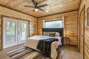 a bedroom with a bed and a ceiling fan at Pets OK! Hot Tub, Waterfront, Starlink, Firepit in Wright City