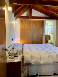 a bedroom with a bed and a table with a lamp at casas lago in Villa Carlos Paz +28 photos