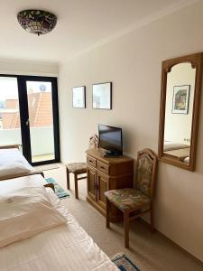 a bedroom with a bed and a mirror and a chair at Germania-58 in Böhl