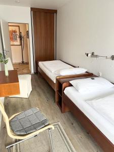 um quarto com duas camas e uma cadeira e uma mesa em Germania-34 em Sankt Peter-Ording