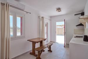 una cocina con un banco de madera en una habitación en Casa Philippi Suites en Mykonos ciudad