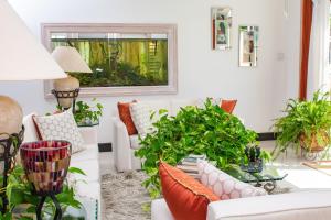 a living room with white couches and plants at ZenBreak Bliss Tranquility in Bridgetown