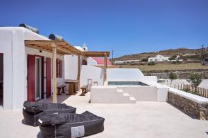 a villa with a swimming pool and white at Casa Philippi Suites in Mikonos