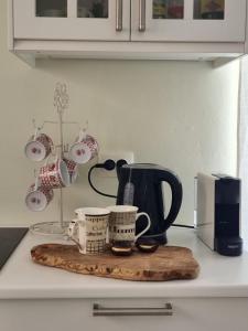 a cutting board with coffee cups on a kitchen counter at Dream Vacation Apartment in Acharavi