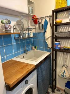 a kitchen with a sink and a washing machine at Casetta BLU in Siracusa