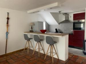 a kitchen with three bar stools and a counter at maison en Camargue in Saintes-Maries-de-la-Mer