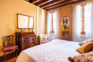 - une chambre avec un lit, une commode et un miroir dans l'établissement appartamento nel cuore di venezia, à Venise