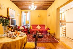 - un salon avec une table et un canapé rouge dans l'établissement appartamento nel cuore di venezia, à Venise