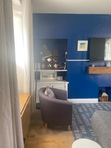 a living room with a chair and a blue wall at Beach Walk in Berwick-Upon-Tweed +10 photos
