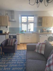 a living room with a couch and a kitchen at Beach Walk in Berwick-Upon-Tweed