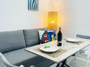 salon z kanapą i stołem z butelką wina w obiekcie Apartamento ALAZUL Soberao w mieście Conil de la Frontera