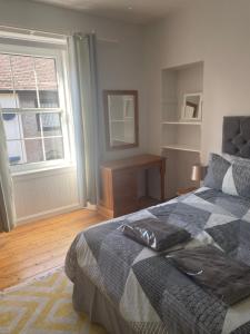 a bedroom with a bed and a window and a table at Beach Walk in Berwick-Upon-Tweed