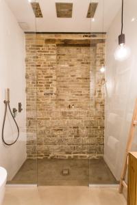 a glass shower in a bathroom with a brick wall at Terra di Gradara in Gradara