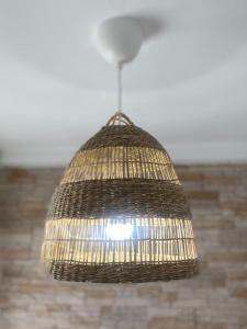 a wicker light fixture hanging from a ceiling at Apartamento Playa Oliva Deluxe in Oliva