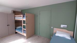 a small bedroom with a bunk bed and a closet at Adveniat Paris in Paris