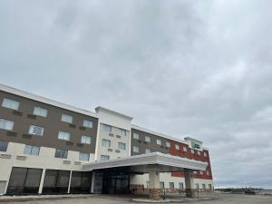 un bâtiment d'hôtel avec un parking en face de celui-ci dans l'établissement Holiday Inn Express Big Rapids, an IHG Hotel, à Big Rapids