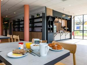 une table avec deux assiettes de nourriture dans l'établissement B&B HOTEL Sélestat Centre-Alsace, à Sélestat